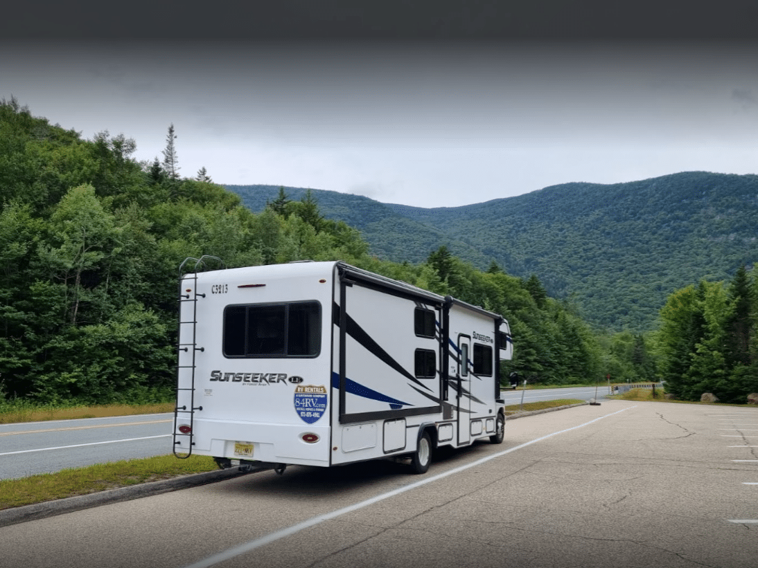 RV on the side of the road with mountains in the background